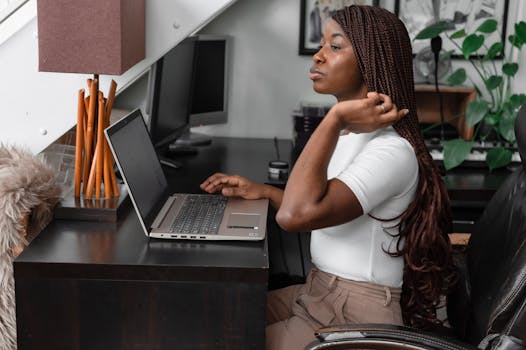African American woman working from home using a laptop, embodying the digital nomad lifestyle.