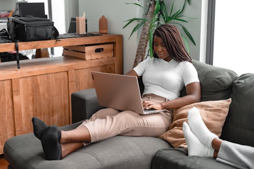 A Woman Using a Laptop While Sitting on a Couch