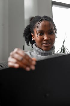 African American woman using a laptop at home for remote work or study.