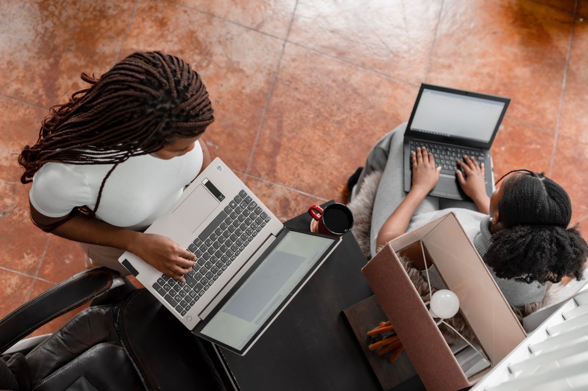 Black women collaborating with laptops in a modern learning environment