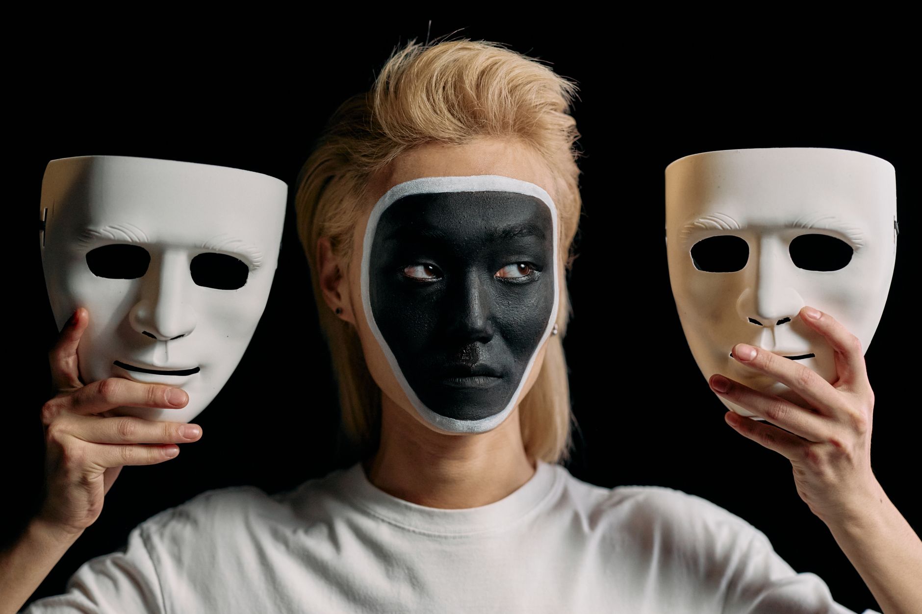 Conceptual studio portrait showcasing art makeup with masks, blending creativity and mystery.