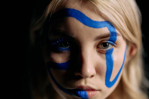 Close Up Photo of Woman with Blue Face Paint
