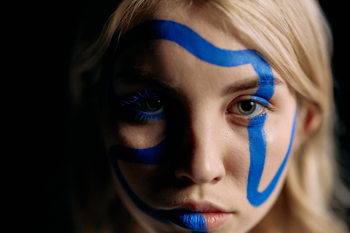Close Up Photo of Woman with Blue Face Paint
