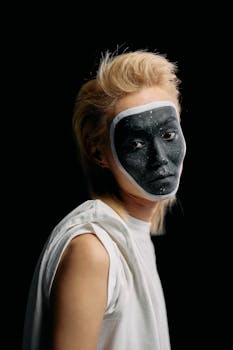 Portrait of a person with creative makeup on a plain black background.