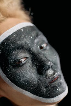 Close-up of creative black and white face makeup in studio lighting.