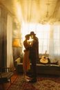 Man and Woman Kissing Near White Window Curtain