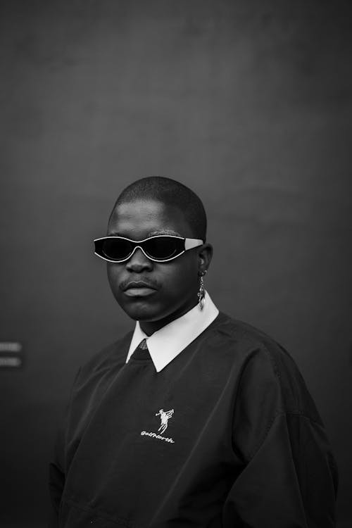 
A Grayscale of a Man Wearing a Sweater and Sunglasses