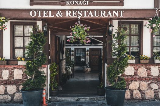 Charming entrance of a hotel and restaurant in Amasya, Turkey, adorned with vibrant plants and flowers.