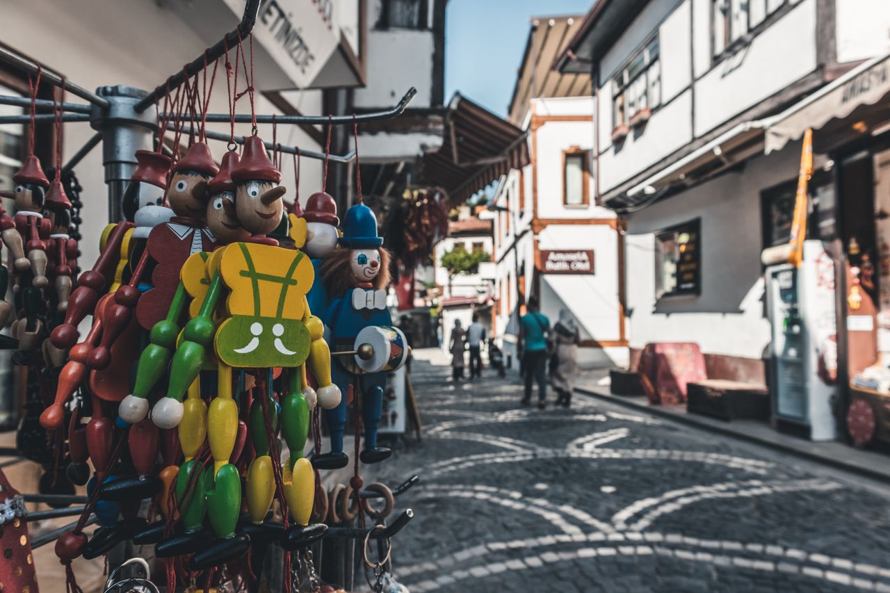 vibrant wooden toys hanging in a charming cobblestone street market in