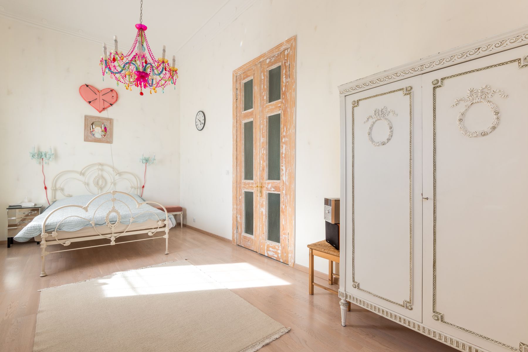 Ornate bed with carved and metal-like historic detailing, pale bedding and classic furniture