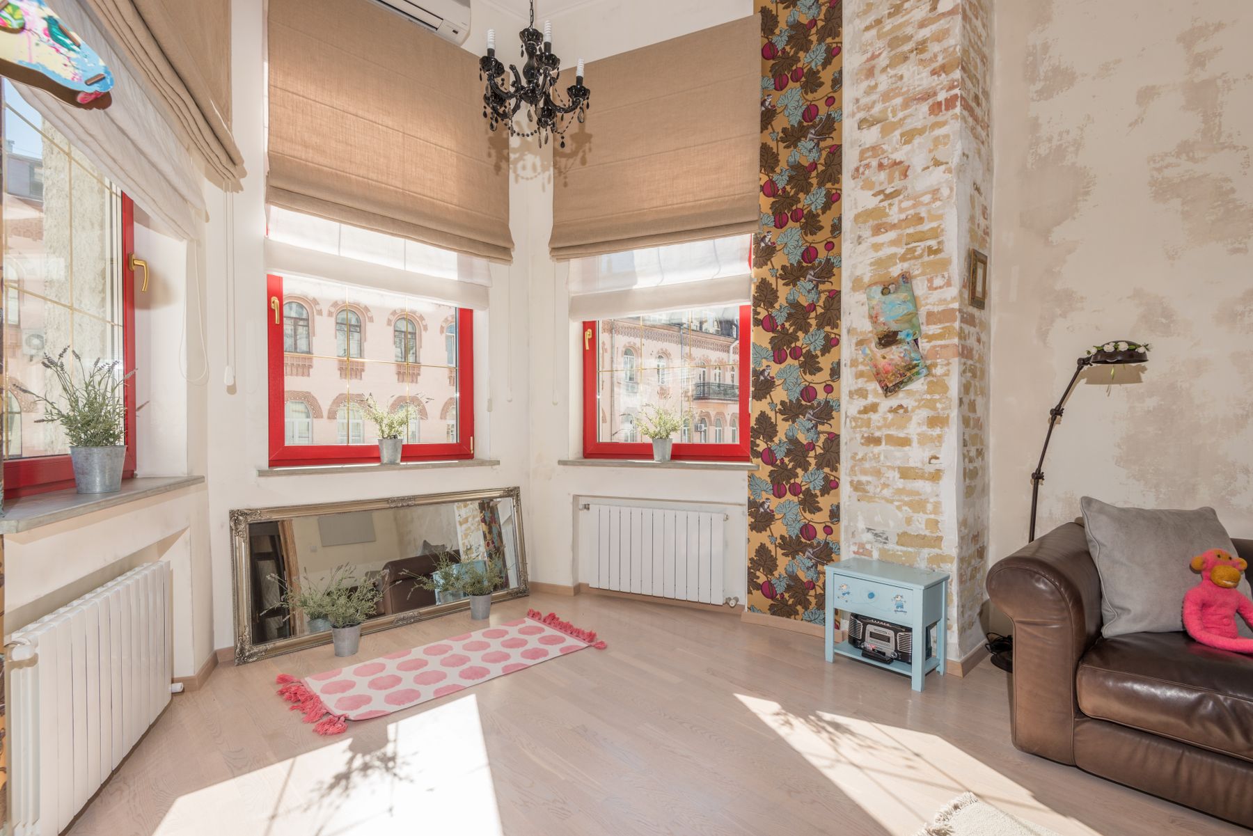 Sunlit vintage apartment corner with floral wallpaper, mirror, chandelier and armchair