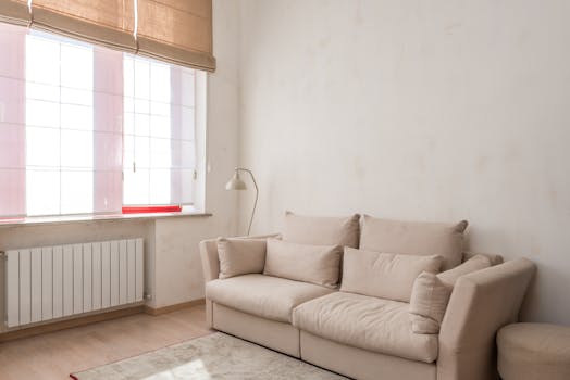 Bright and airy minimalist living room featuring a beige couch and natural light.