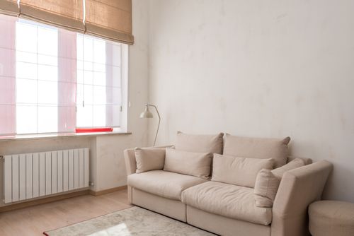 Free Bright and airy minimalist living room featuring a beige couch and natural light. Stock Photo