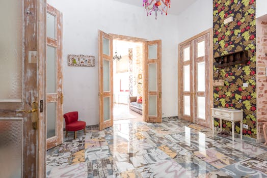 A vibrant, eclectic interior featuring colorful floors, wooden doors, and vivid wallpaper.