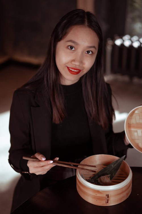 Woman in Black Long Sleeve Shirt Holding Chopsticks