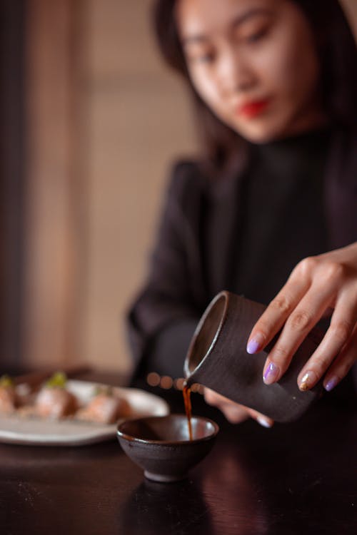 Woman Pouring Tea into a Cup