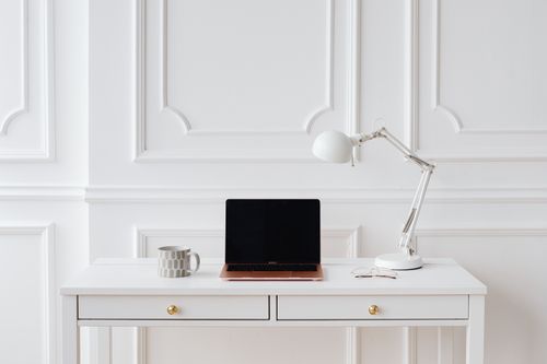 Free Elegant minimalist workspace with laptop and desk lamp on a white desk in a bright room. Stock Photo