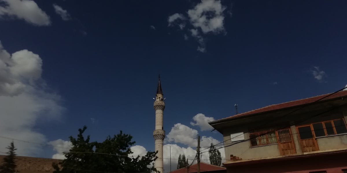 Simple laptop setup with notebook and coffee on a wooden desk