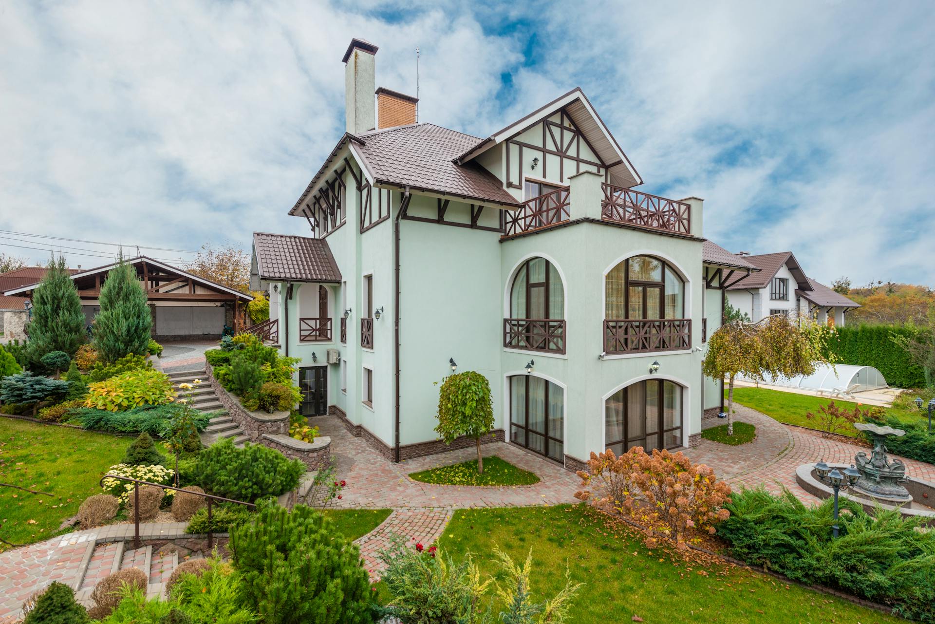 Stunning suburban home with lush garden and modern architectural design, featuring spacious balconies.