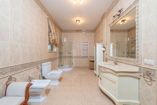 Free Spacious luxury bathroom featuring beige tiles, elegant furnishings, and modern fixtures. Stock Photo