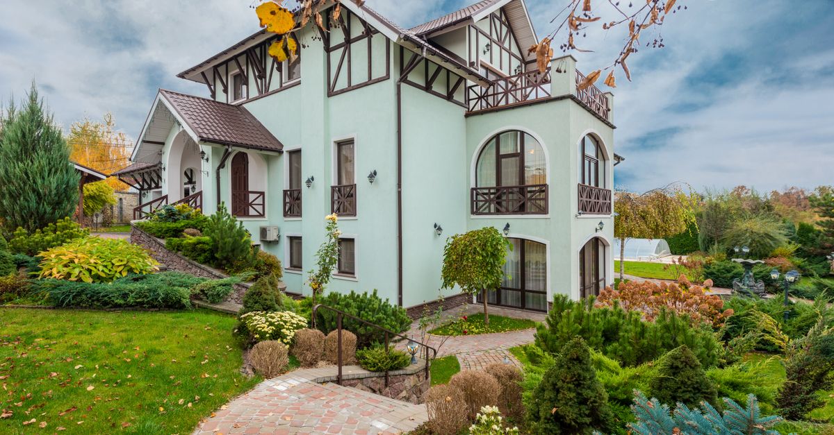 Beautiful traditional house with a garden in autumn showcasing architecture and landscaping.