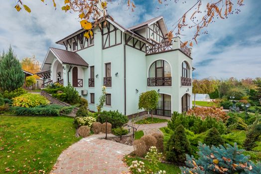 Beautiful traditional house with a garden in autumn showcasing architecture and landscaping.