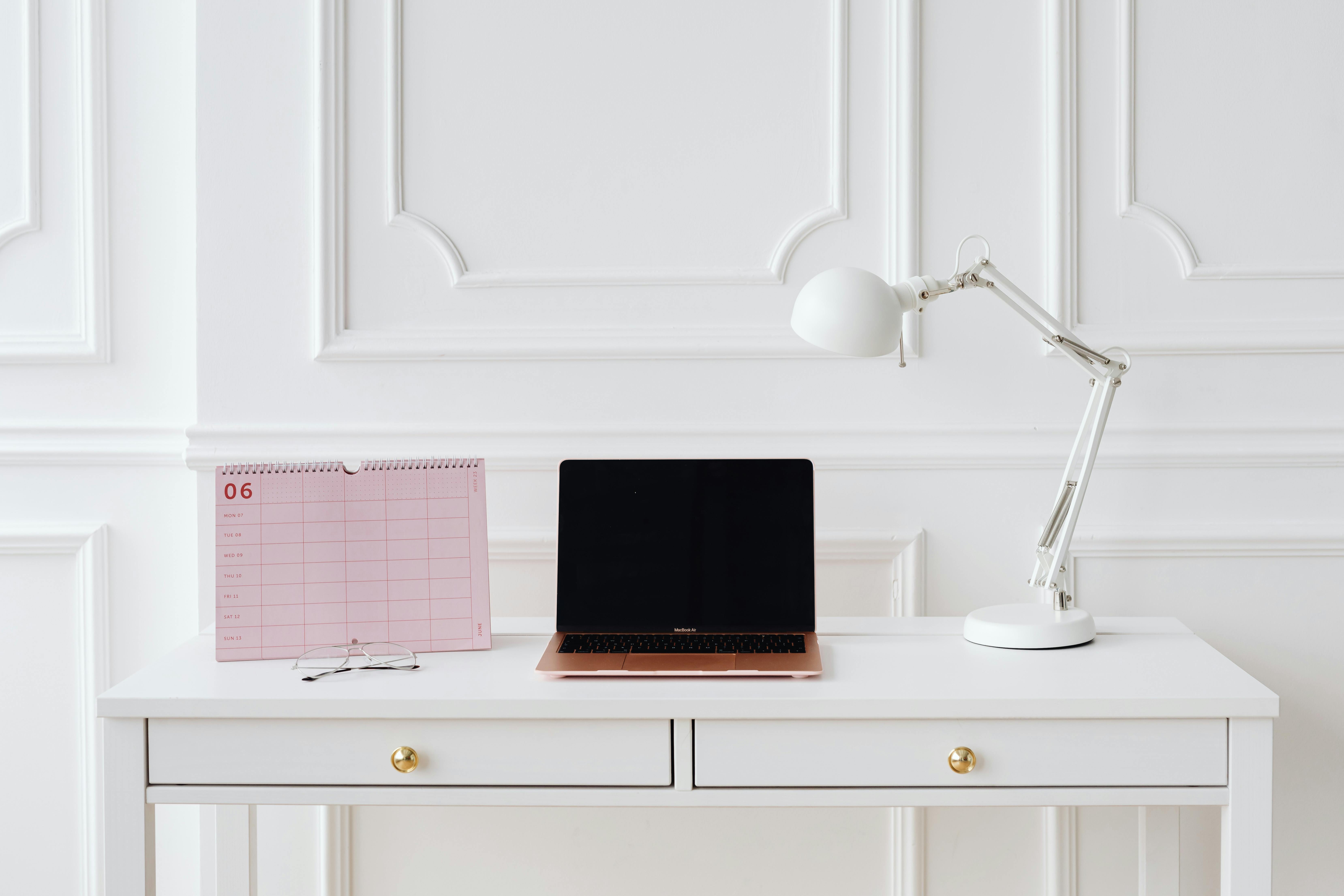 A Laptop and Calendar on the White Table