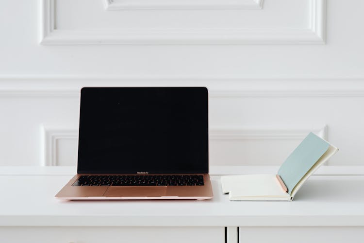 Laptop And A Notebook On A Desk 