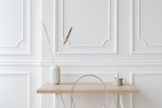 Elegant minimalist decor featuring a pampas grass vase and cup on a wooden table.