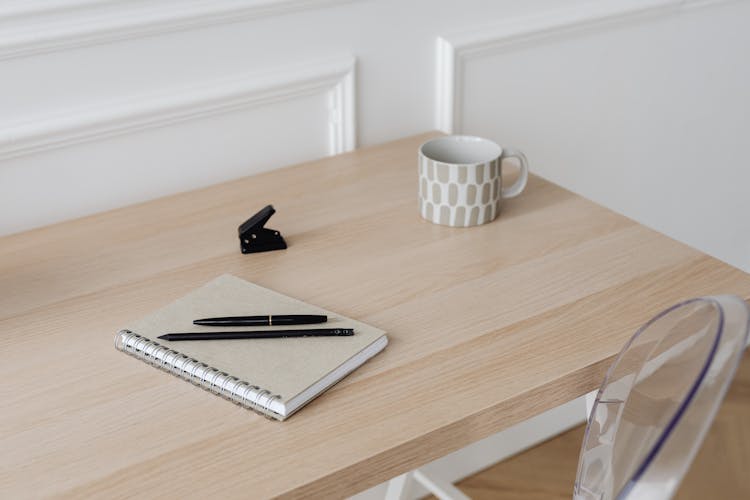 A Notebook And Pens On The Table