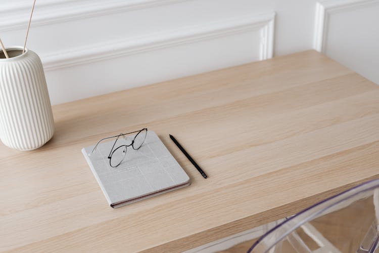 Eyeglasses And Notebook On The Table 