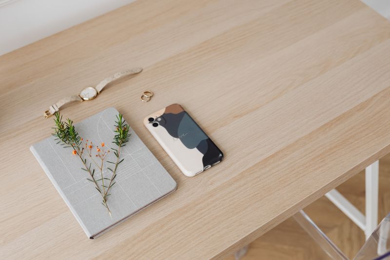Desk flat lay with notebook, phone, and plant — photo by Kaboompics on Pexels