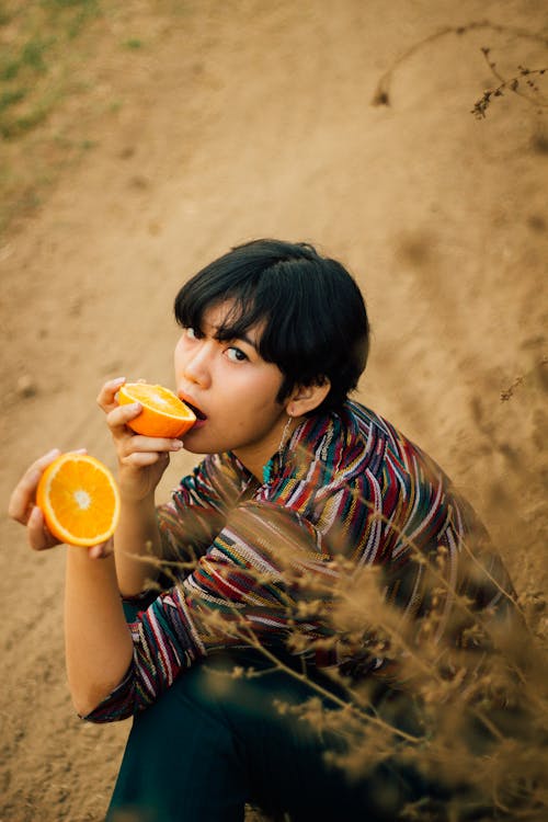 Young Woman Eating A Sliced Orange Fruit