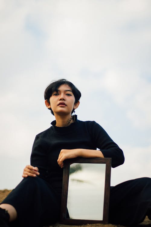 Photo of Woman Holding a Mirror