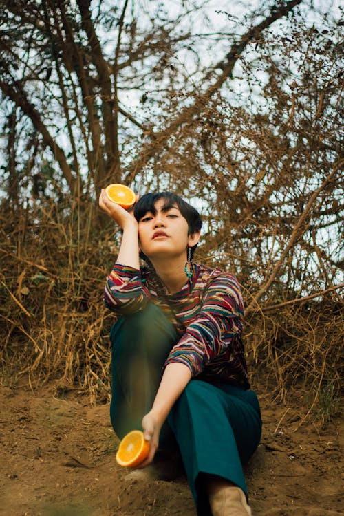Woman Holding a Sliced Orange Fruit