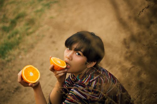 Photo of Woman Holding Sliced Orange