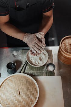 A chef prepares dough with bamboo steamers, highlighting Asian culinary practices.