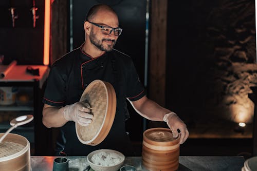 Cook Opening Bamboo Steamer in Kitchen