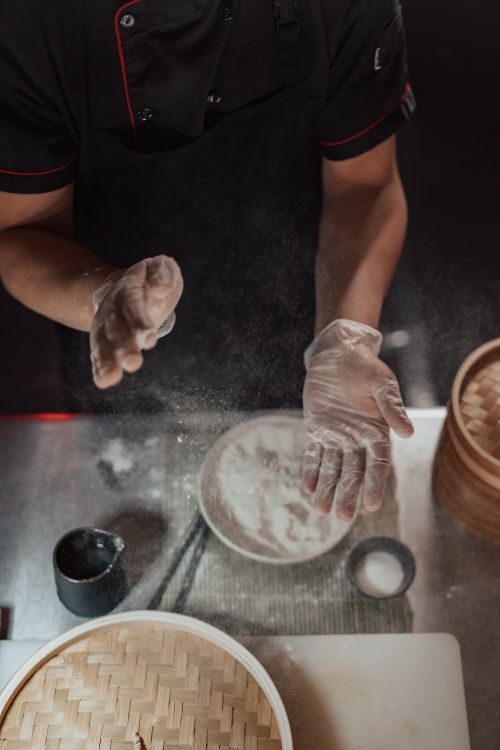 Free A chef expertly prepares dumplings with flour in a kitchen, showcasing culinary skills. Stock Photo