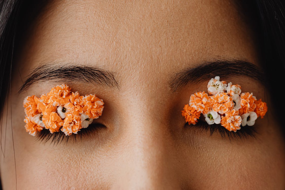 White and Orange Flower on Woman's Eyes
