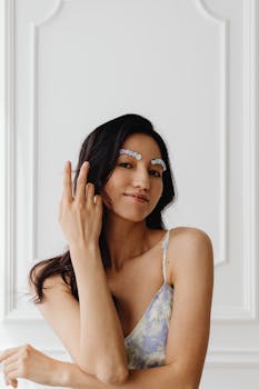 Stylish portrait of a woman with floral eyebrows posing indoors.