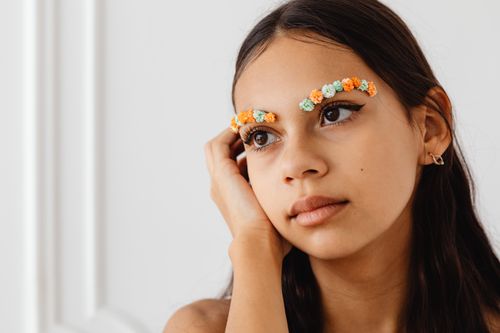Free A close-up portrait of a girl with creative floral eyebrow makeup. Stock Photo