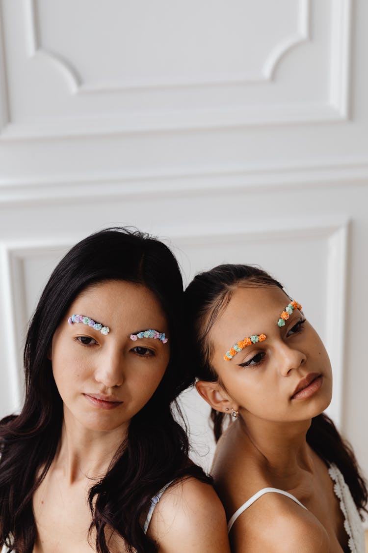 Close-Up Shot Of Two Girls With Flower Brows
