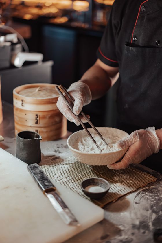 Real photograph of a chef mixing flour and food ingredients in a bowl
