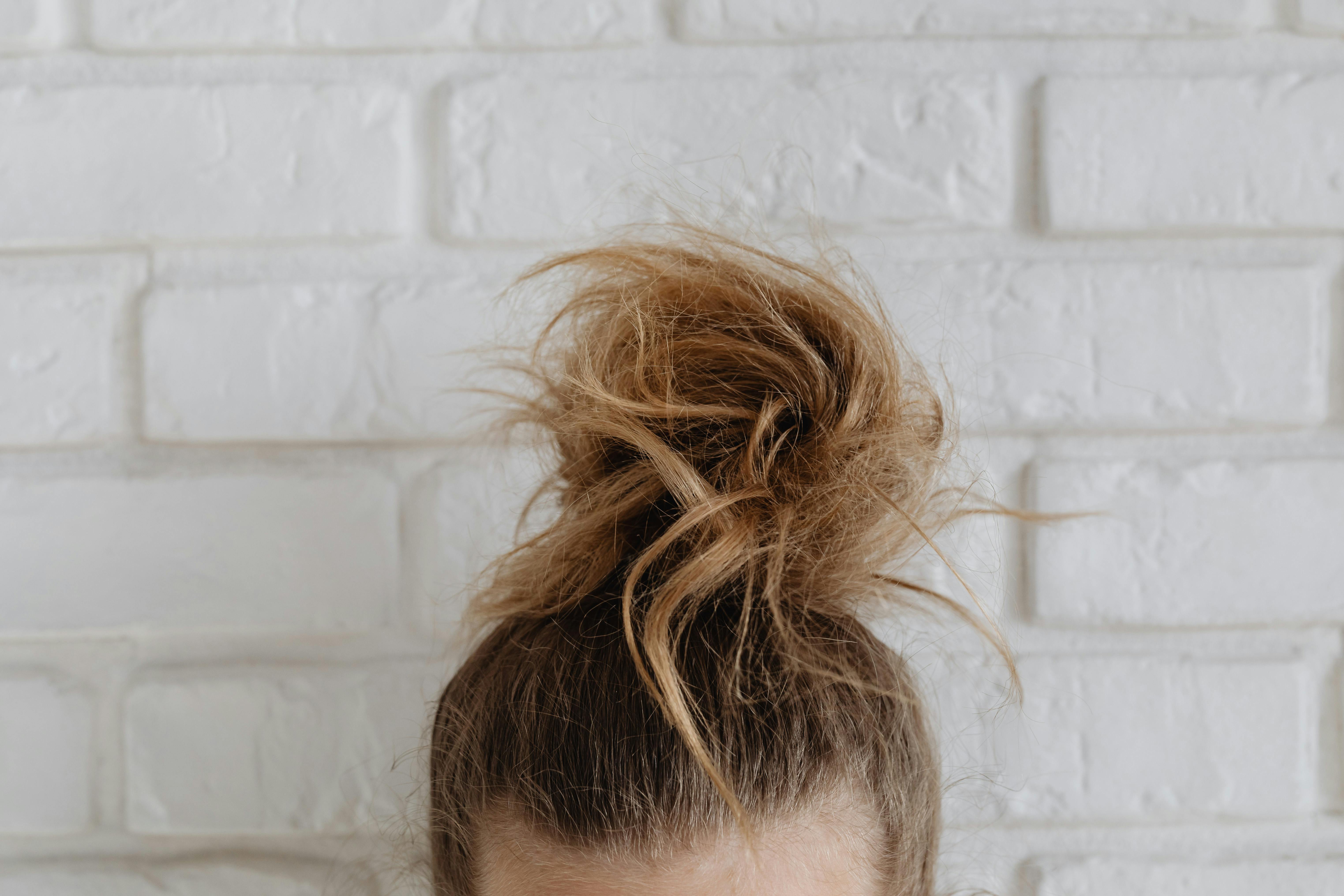 Step-by-step messy bun tutorial showing quick hair styling technique - Beauty hacks for busy women