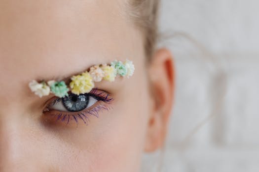 Artistic close-up of an eye with a floral eyebrow decoration, emphasizing creativity.