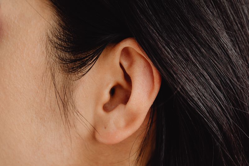 Femme se protégeant l'oreille illustrant la prévention de la fatigue auditive