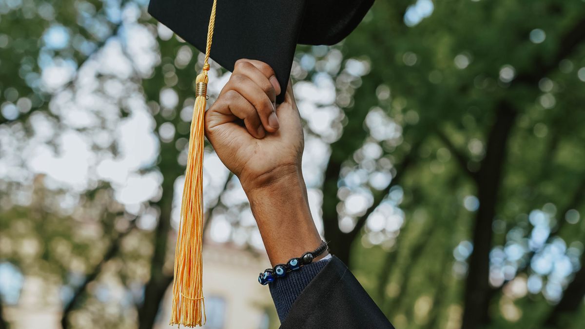 Person holding a black graduation cap