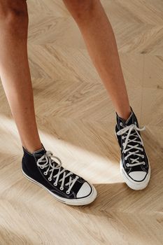 A Person Wearing Black and White Converse All-Star High Top Sneakers