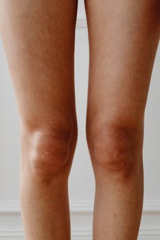 Detailed close-up of human knees, emphasizing skin texture and natural appearance.